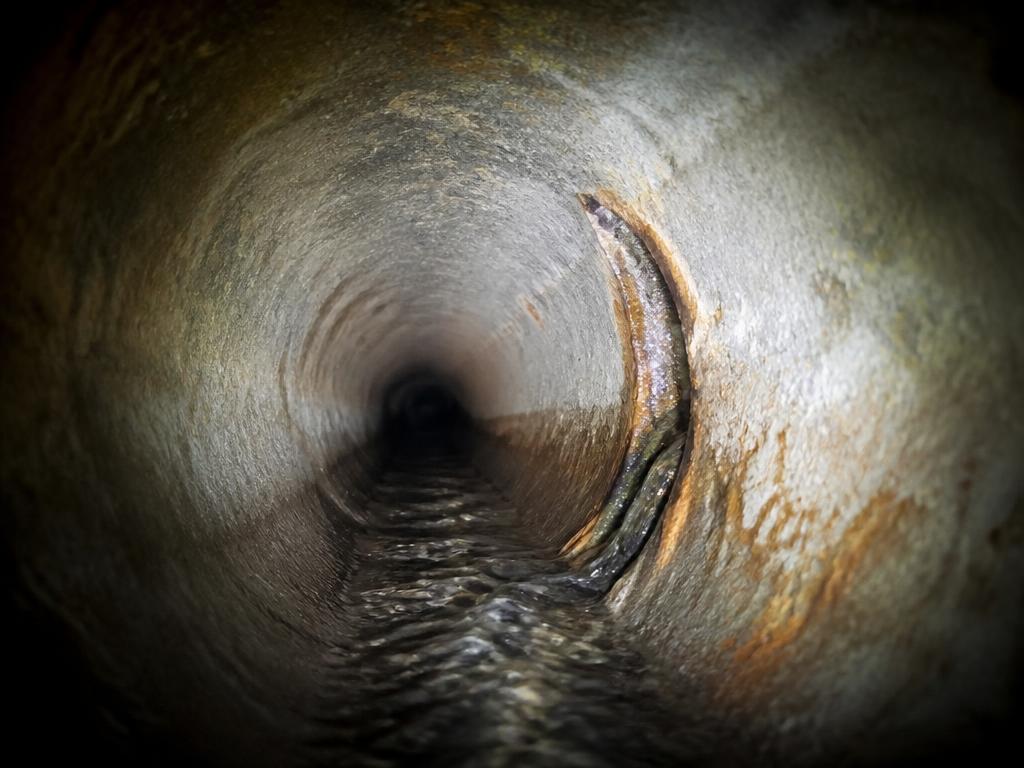 AI-generated placeholder: corroded concrete pipe with a displaced joint and infiltration